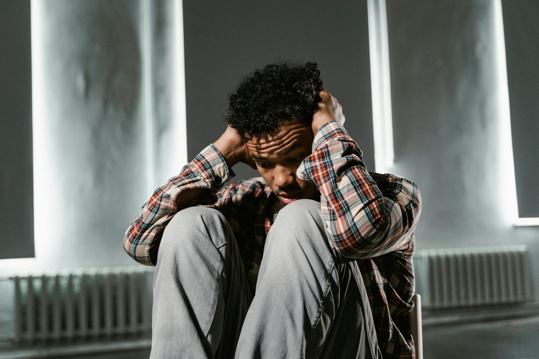 a frightened man sitting alone on a chair